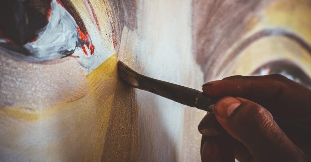 A close-up view of a hand using a paintbrush on a canvas with vibrant colors.