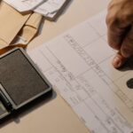 Detailed view of a hand taking fingerprints on a document with ink pad on desk.