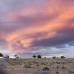 Captivating sunset over Arizona desert with vibrant clouds and open landscape.